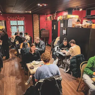 The red dining room with every table busy, fairy lights in the window