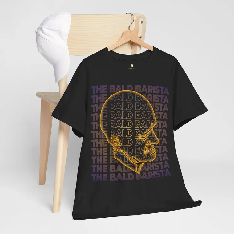 Black T-shirt on a wooden hanger with a neon outline of Buzz’s head over repeated lines reading The Bald Barista